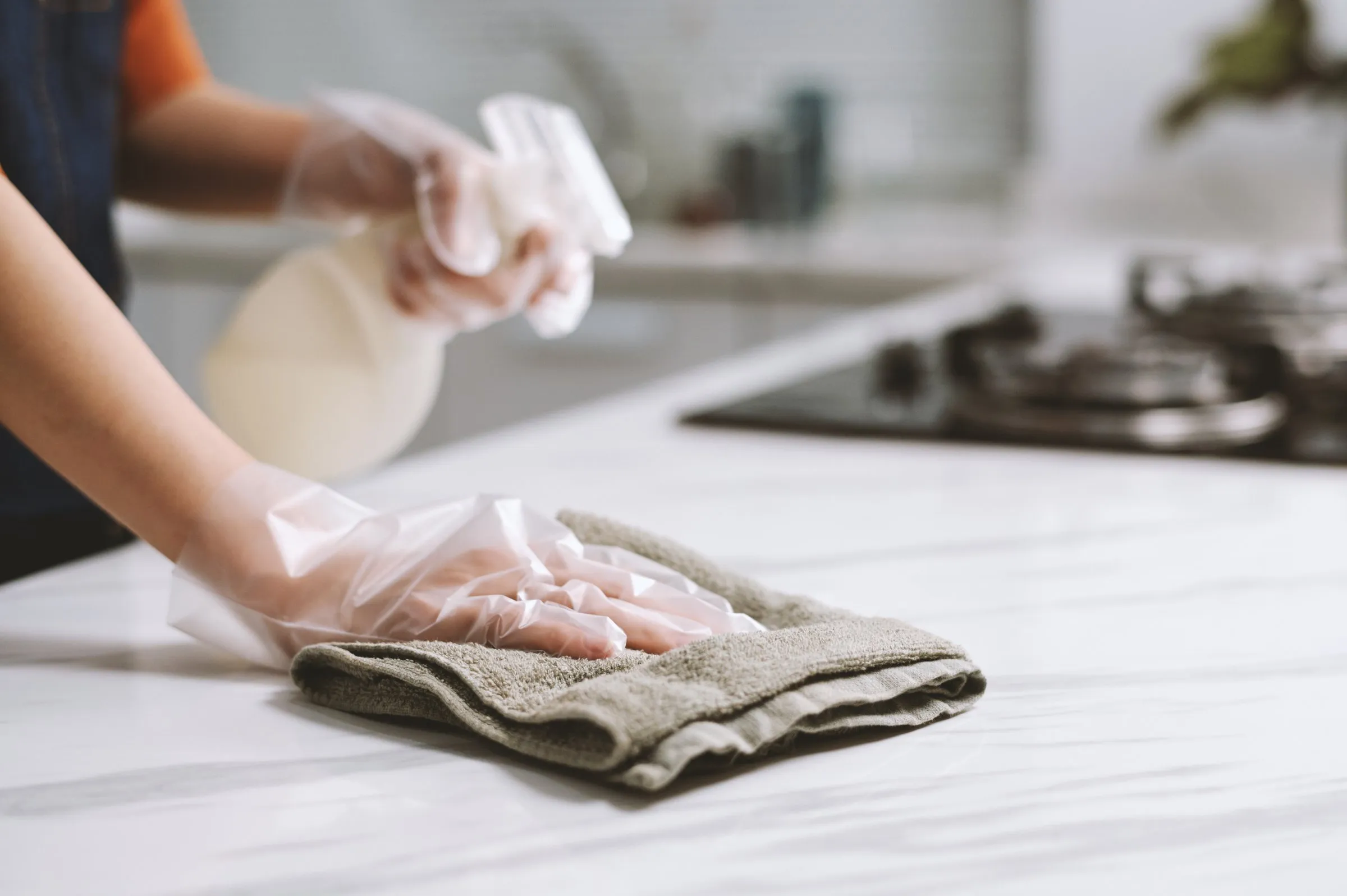 DITA Pro Clean cleaner wiping a marble kitchen counter with a cloth in a Metro Detroit home