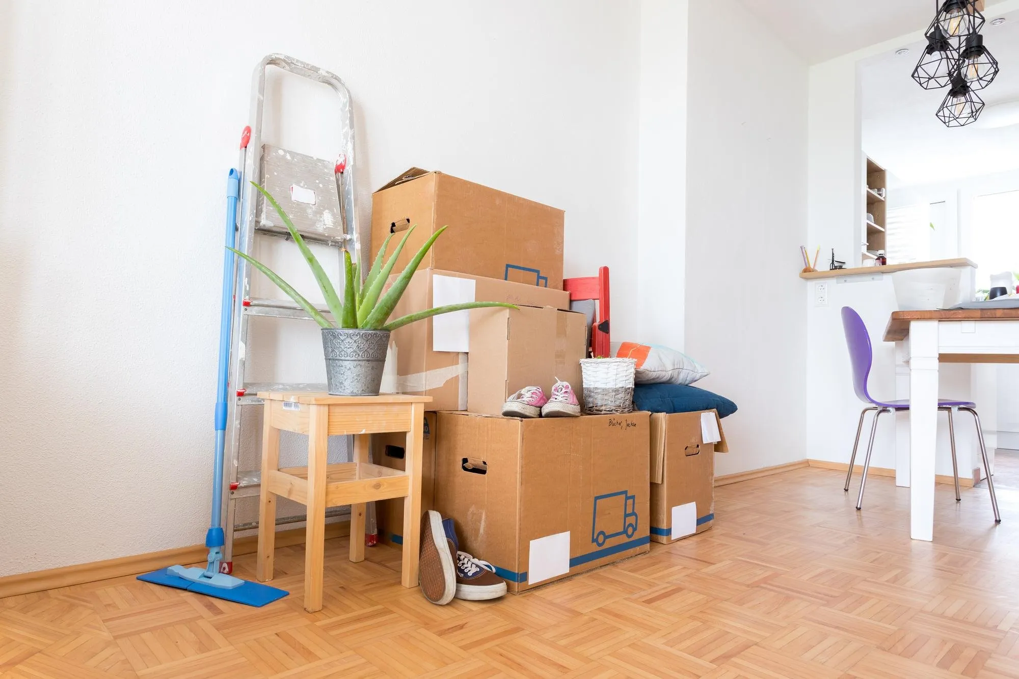Packed moving boxes and a mop in an empty Clinton Township home ready for a move out clean by DITA Pro Clean
